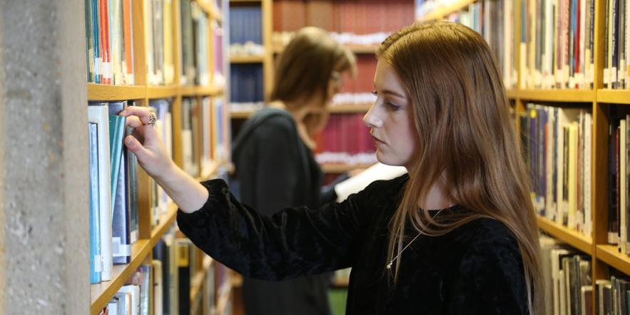 Students browsing library shelves
